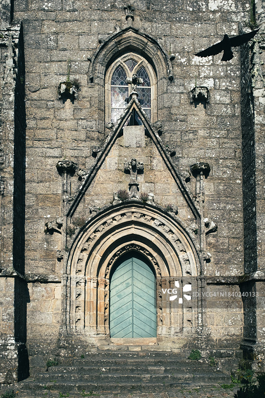 法国布列塔尼Locronan圣罗南教堂前飞翔的鸟图片素材