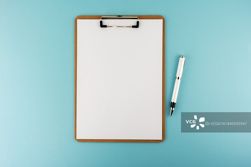 蓝色背景上的空白剪贴板和笔图片素材