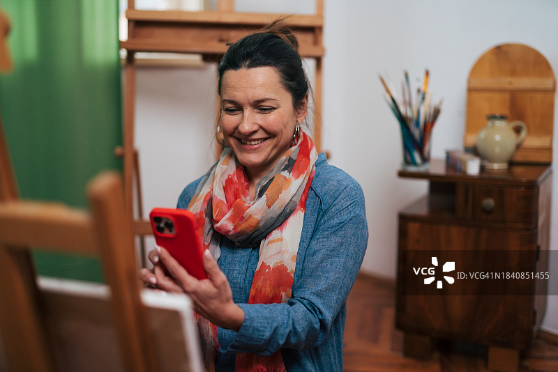 在艺术工作室绘画的中年女画家图片素材