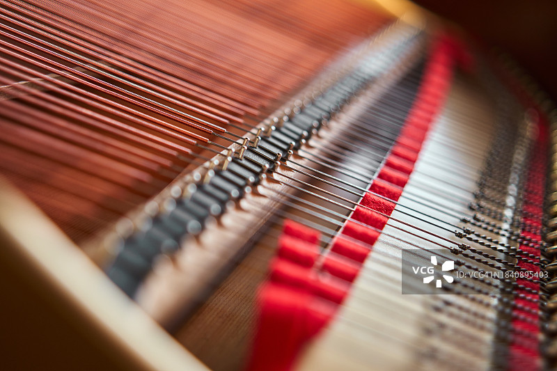 房间内木质底座上的彩色钢琴琴弦合集图片素材