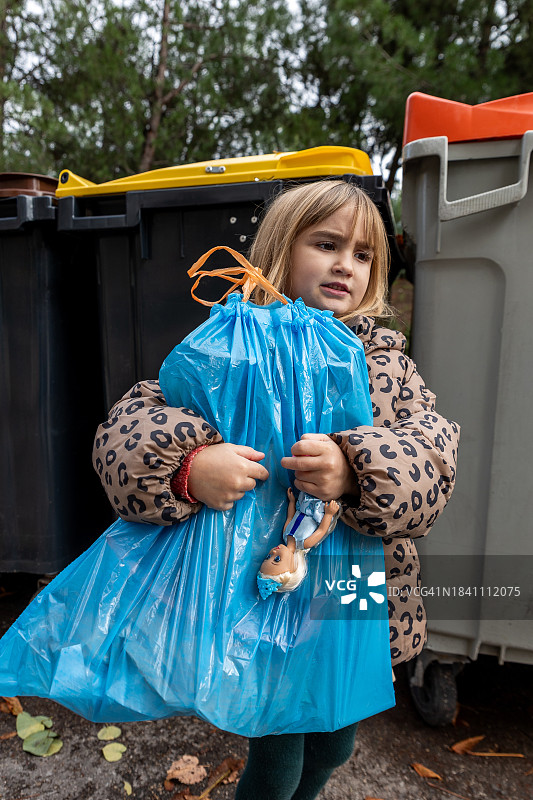 小女孩提着垃圾回收袋图片素材