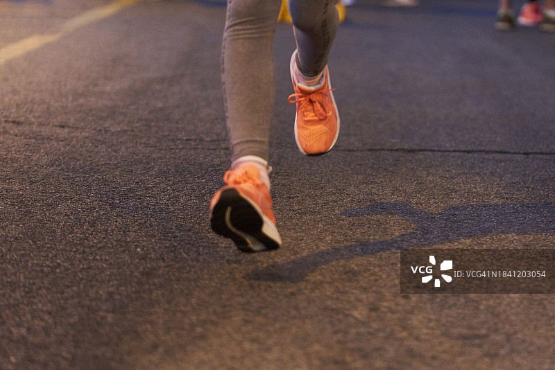 夜晚在街上跑步的人的腿部特写图片素材