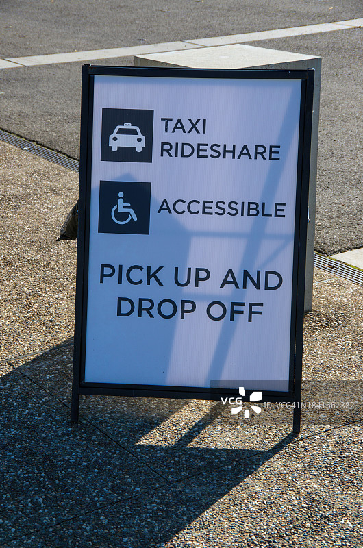 人行道上写着“出租车、共享汽车、无障碍接送”的折叠标志牌图片素材