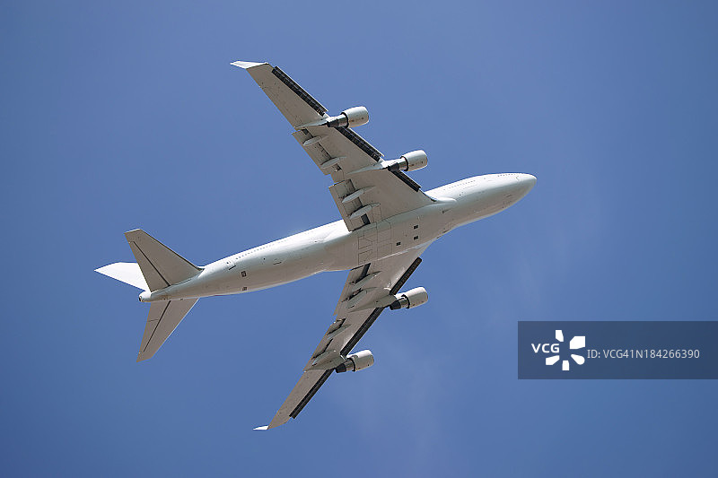 蓝色天空下的白色波音747-400图片素材