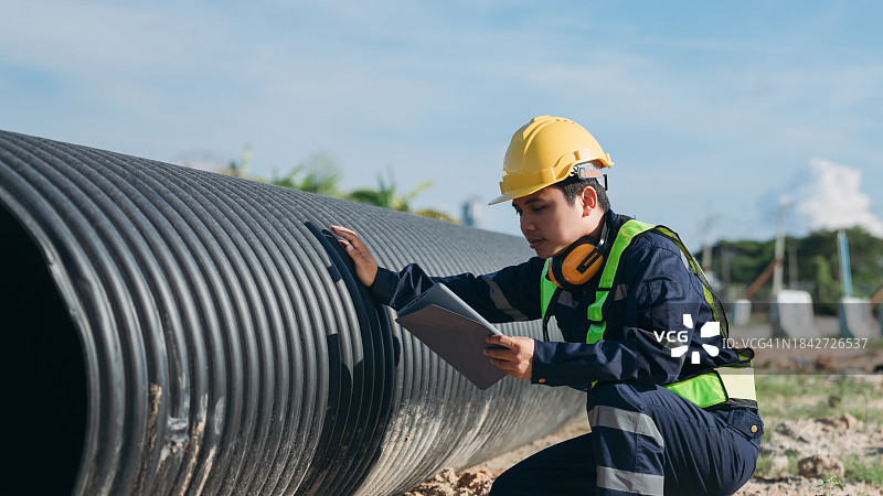 工程师检查用于水、石油、天然气和燃料运输管道的圆形水管结构图片素材