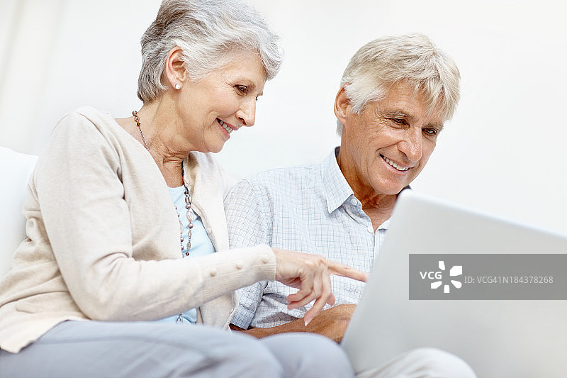 快乐的老年夫妇使用笔记本电脑图片素材