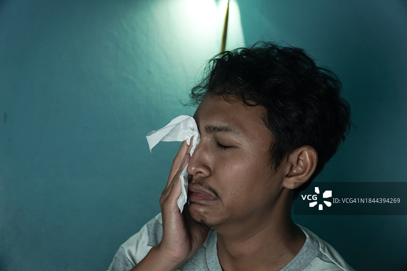 用纸巾擦拭眼泪的亚洲青少年图片素材