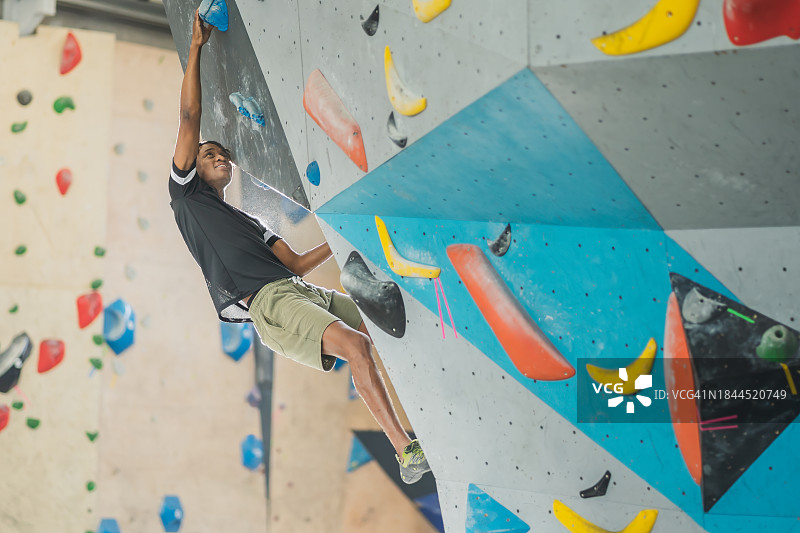 室内攀岩墙上倒立的攀岩者图片素材