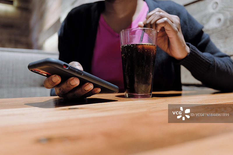 女人在餐厅喝饮料时查看手机图片素材