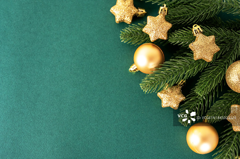 金色圣诞装饰与绿色背景上的松针图片素材