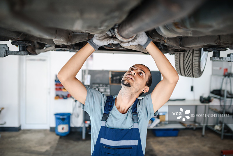专业汽车修理工检修车辆底盘图片素材