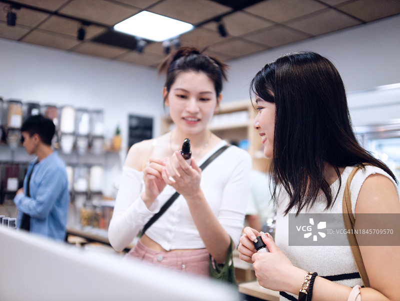 两名年轻女性带着环保意识和兴奋感进入无包装商店图片素材