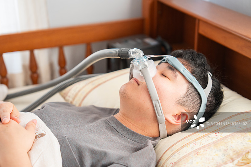 男子使用呼吸机治疗睡眠呼吸暂停图片素材