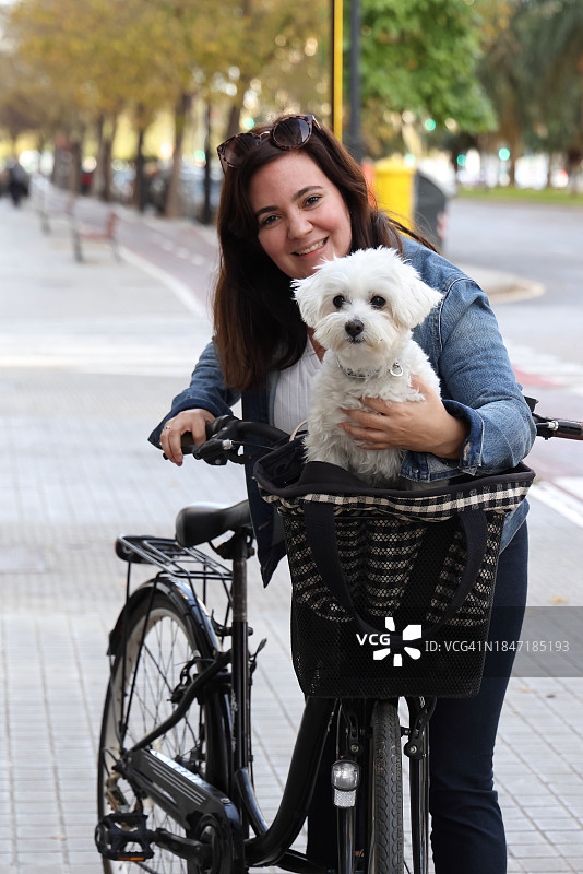 女士推着载有小狗的自行车图片素材
