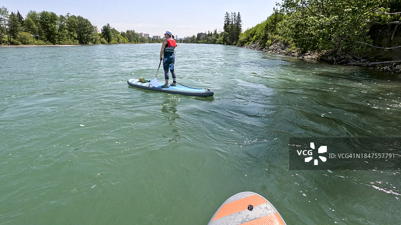 女子在立式桨板上划桨的主观视角图片素材
