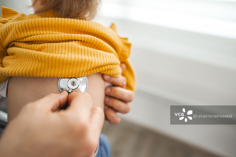 男儿科医生在诊所听小女孩的肺部活动图片素材