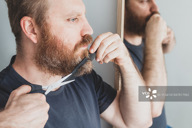 男人在灰色背景前刮胡子的特写镜头图片素材