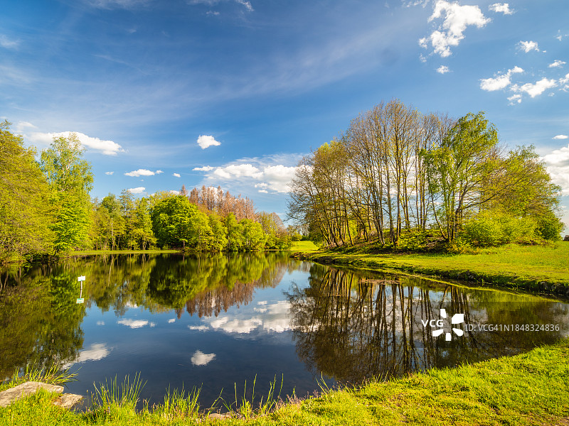 法国东部千塘高原小芬兰地区池塘的广角景观，树木倒映其中图片素材
