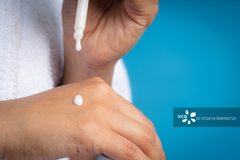 往手上涂抹乳霜的人图片素材