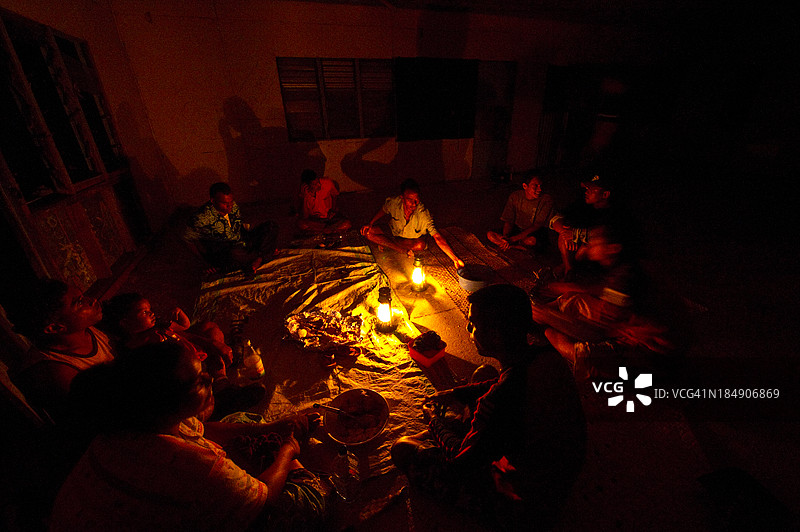 村民们在学校里享受着用煤油灯照明的卡瓦仪式。图片素材