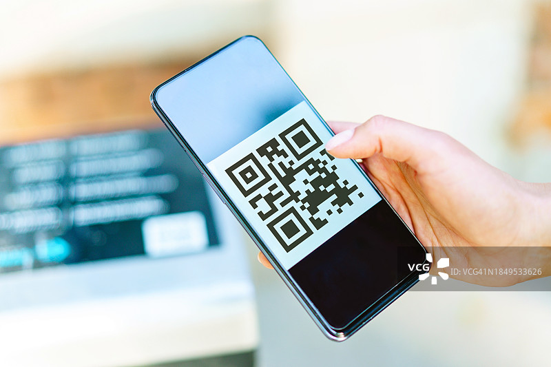 女士用智能手机扫描数字二维码特写图片素材