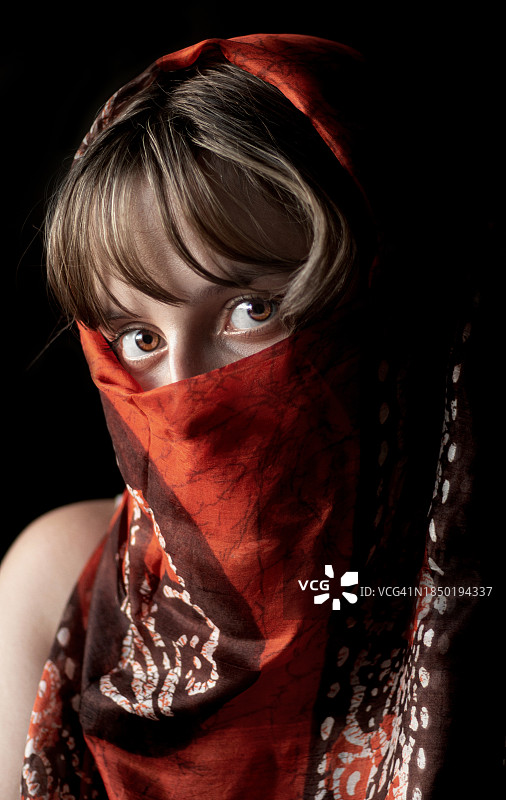 戴围巾的年轻女人在黑色背景前图片素材