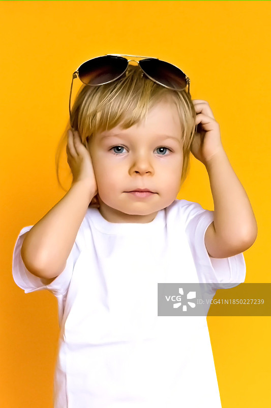 在黄色背景下听音乐的可爱女孩肖像图片素材