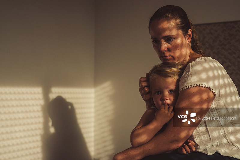 母亲在家中抱着受惊的女儿图片素材