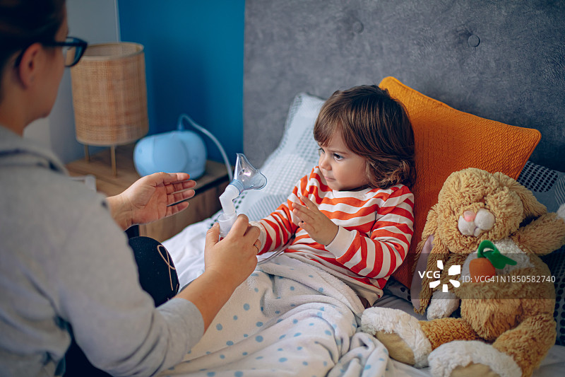 小男孩在家和妈妈一起做雾化图片素材