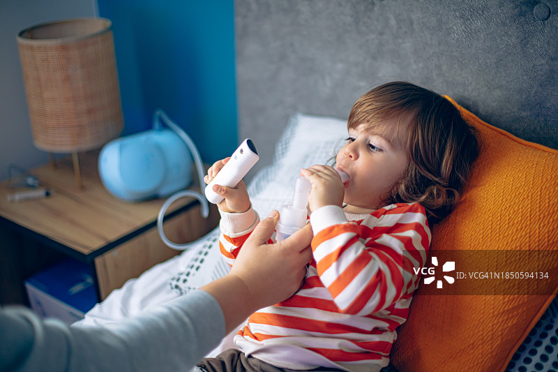 小男孩在家和妈妈一起做雾化图片素材