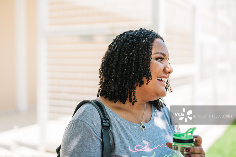 微笑的年轻女人在上学路上图片素材