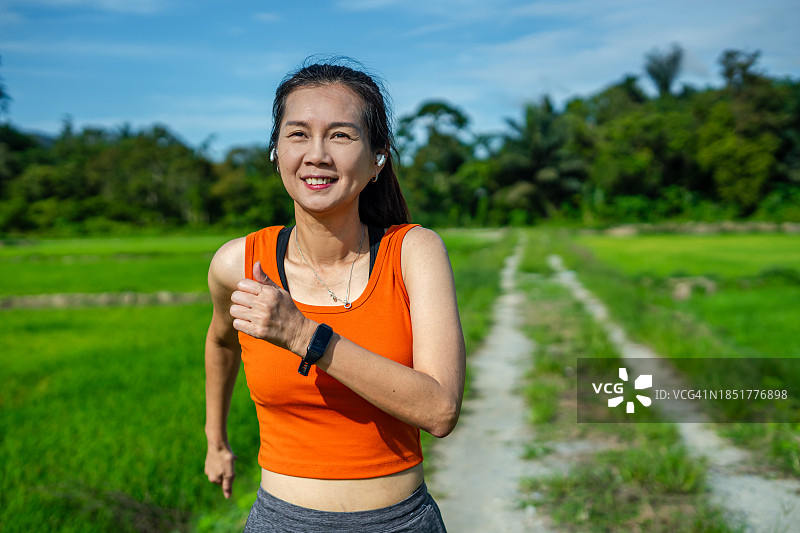 在田野中慢跑的运动型女人图片素材