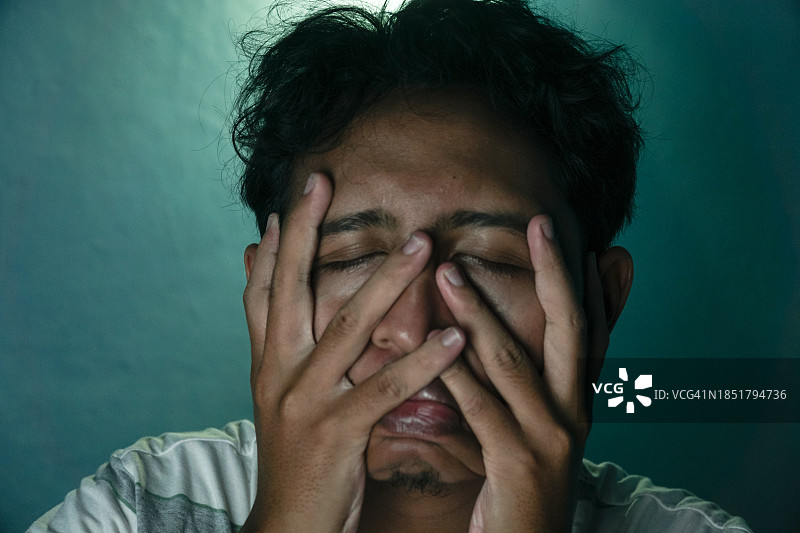 青少年悲伤地挠脸图片素材