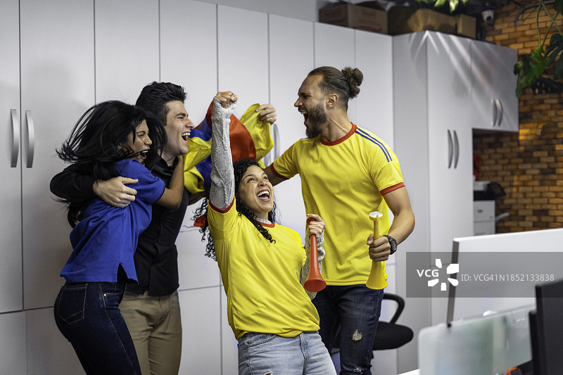 男女在办公室观看足球比赛图片素材