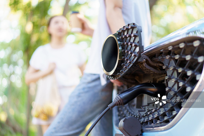 男人和女人准备给电动汽车充电图片素材