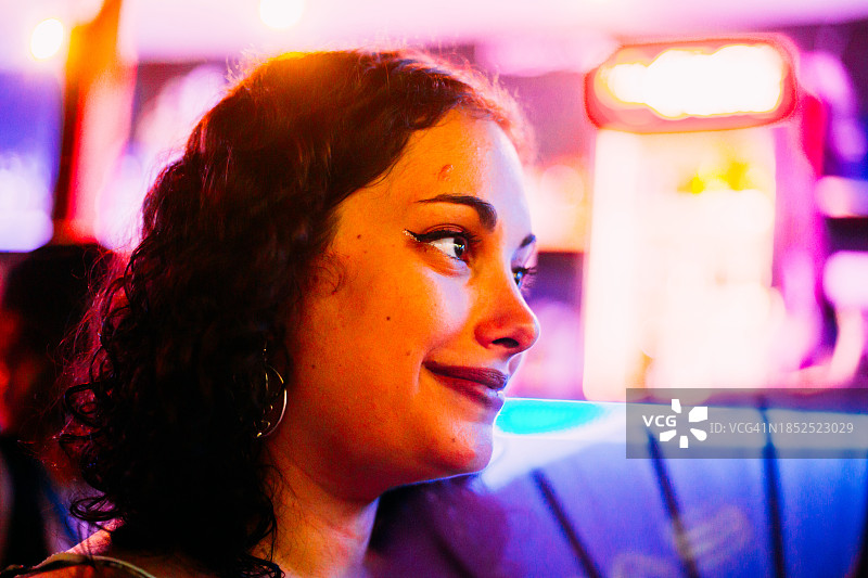 卷发漂亮女人霓虹灯下。图片素材