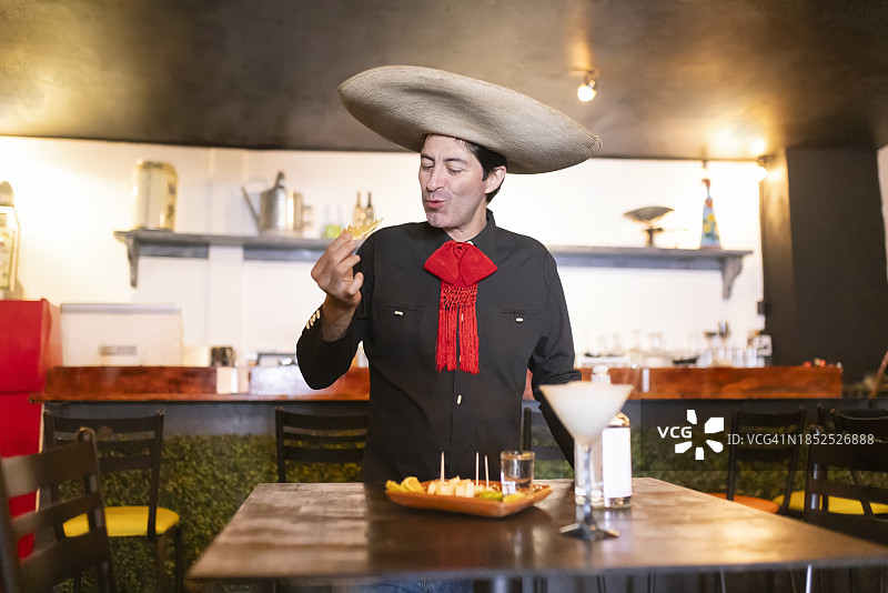 喝完龙舌兰酒后吃橙子的墨西哥男人图片素材