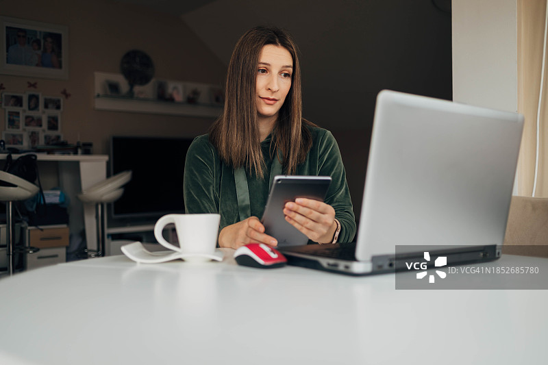 女人在家使用平板电脑和笔记本电脑图片素材