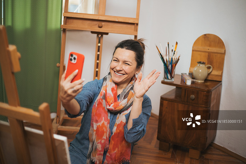 女艺术家在画室进行视频通话图片素材