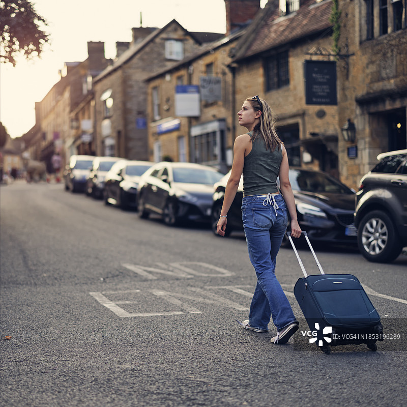少女在英国格洛斯特郡科茨沃尔德的村庄里散步图片素材