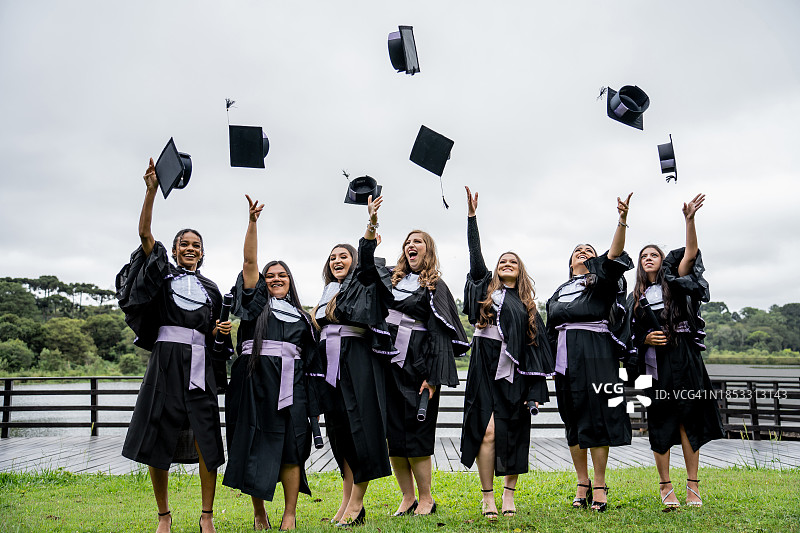 学生们把毕业帽扔向空中图片素材