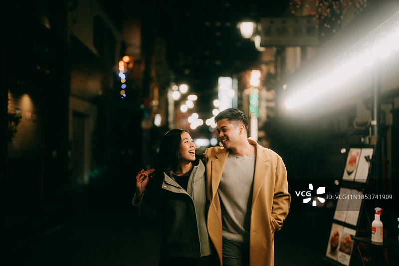 情侣在冬季夜晚享受东京后街的浪漫图片素材