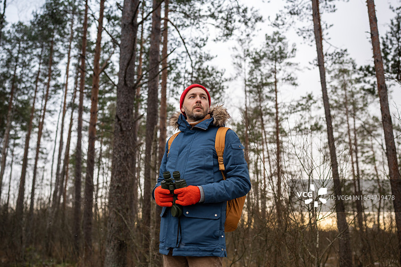 在森林中用双筒望远镜探索自然的观鸟游客图片素材