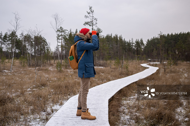在公园里用双筒望远镜观鸟的自然爱好者图片素材
