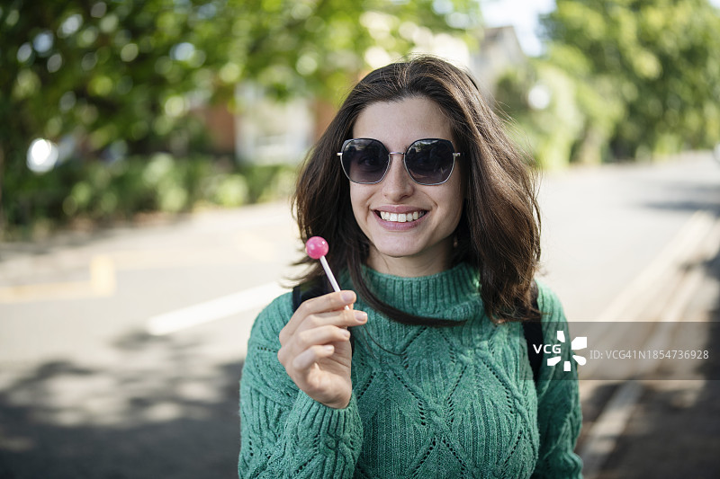 拿着棒棒糖的年轻女人肖像图片素材