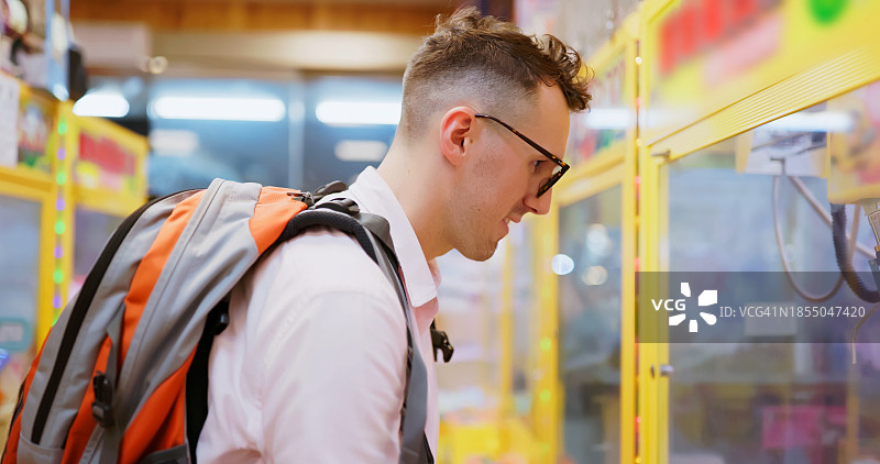 男人参观抓娃娃机店图片素材
