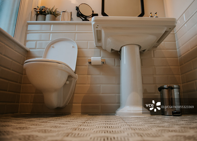 仰视角度拍摄的现代浴室中的水槽和马桶图片素材