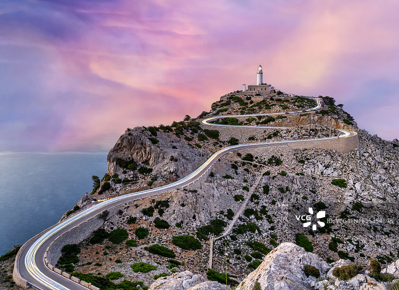 海边山顶的灯塔，日落时分有道路和行驶的汽车图片素材