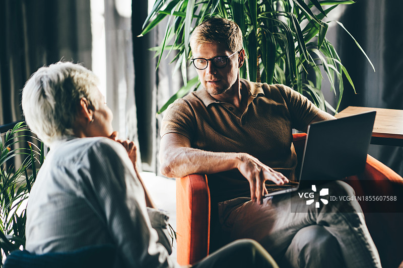 两位商务人士在办公室里一起工作。商务人士向同事解释他的愿景图片素材