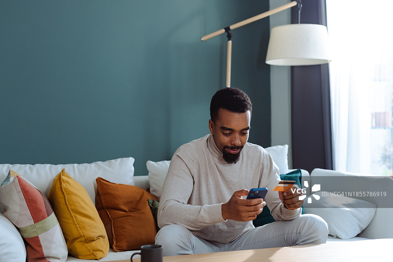 使用在线支付服务的年轻非裔美国男子图片素材